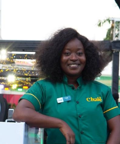 Chalé App crew member leaning forward, smiling, in a green uniform shirt