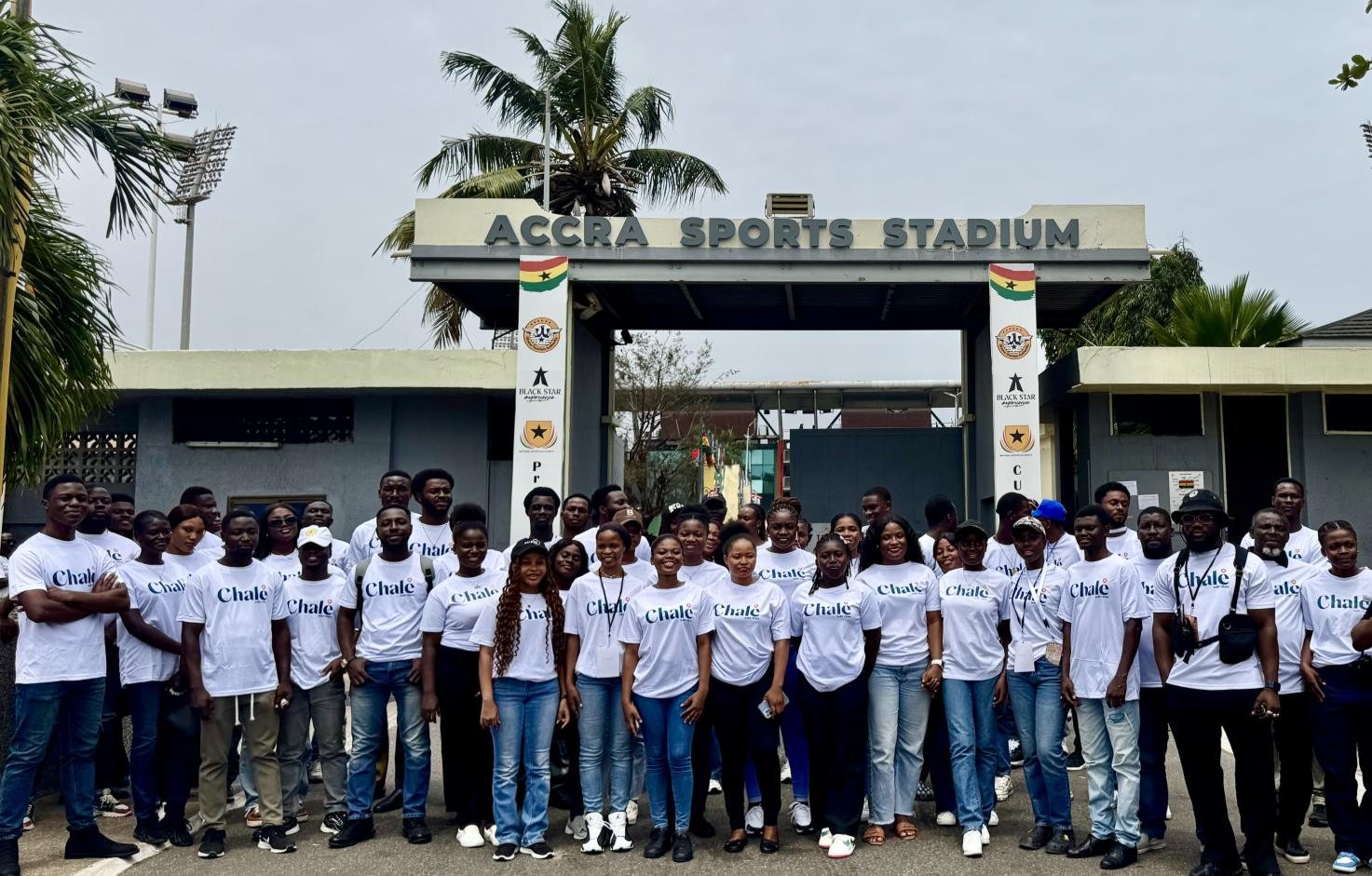 Event staff in Chalé T-shirts gathered at the entrance to Accra Sports Stadium